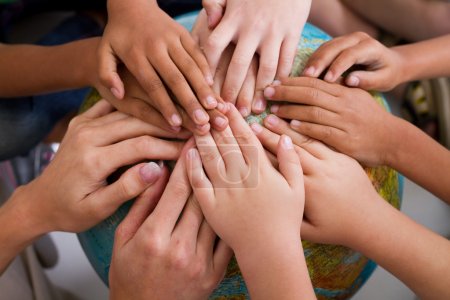 Diversity kids hands together on globe