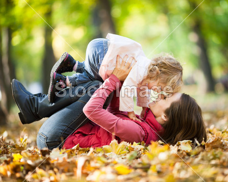 Woman with child having fun in autumn park
