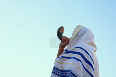 Jewish man blowing the Shofar (horn) of Rosh Hashanah (New Year)