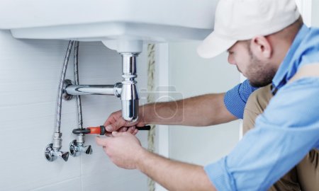 Plumber hands fixing water tap