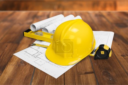 Yellow hard hat and blueprints 