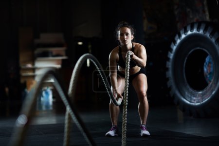 woman practicing exercise with ropes