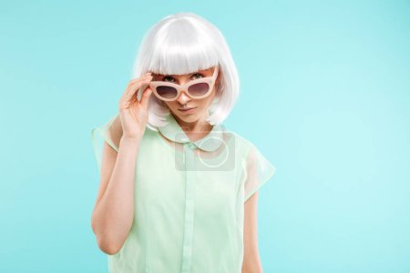 Portrait of beautiful young woman in sunglasses and blonde wig