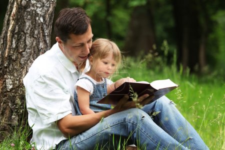 Dad and daughter reading the Bible
