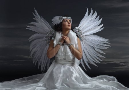 Young beautiful woman in angel costume with wings, natural feath