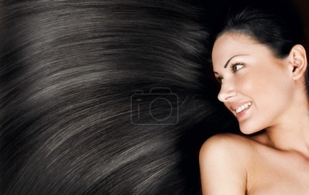 Close-up portrait of a beautiful young woman with elegant long shiny hair, conceptual hairstyle