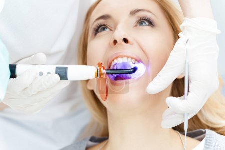 Patient whitening teeth at dentist