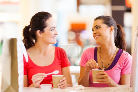 Two happy friends having drinks in cafe