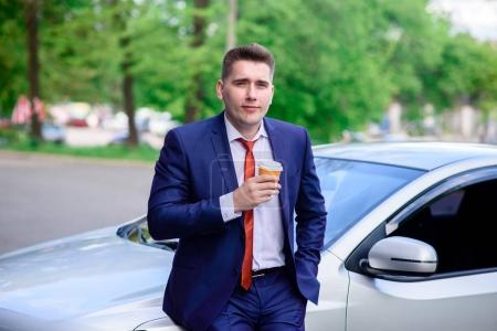 Businessman drinking coffee in the car.