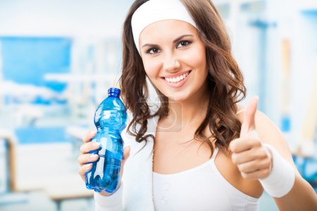 Woman with bottle of water, at fitness club