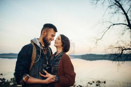 young couple hugging near river