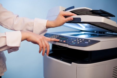 Woman's hand with working copier