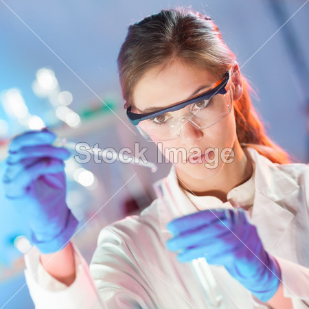 Attractive young scientist pipetting.