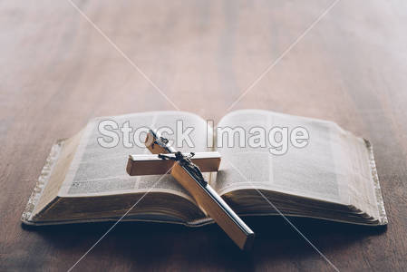 christian cross on open holy bible