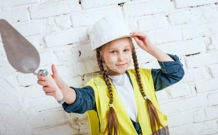 Little cheerful girl with braids playing in repair or construction