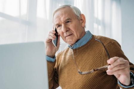 Senior busy man working in office and making phone call