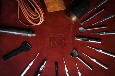 top view of leather metal tools on red surface