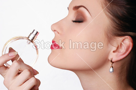 Beautiful woman smelling her perfume
