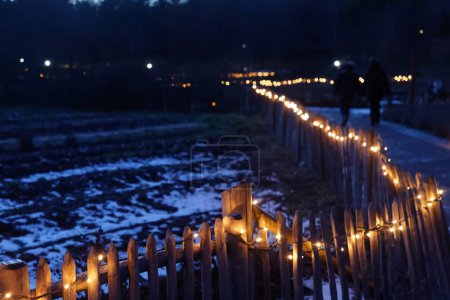 Fence with electric light at the Christmas Fair and fire show at