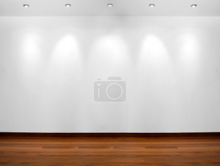 Empty white wall with 3 spot lights and wooden floor