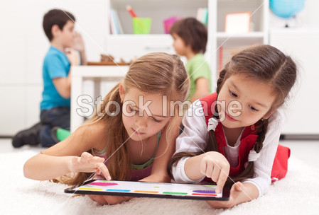 Little girls playing on a tablet computing device