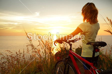 Young lady standing with bicycle