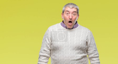 Handsome senior man wearing winter sweater over isolated background afraid and shocked with surprise expression, fear and excited face.
