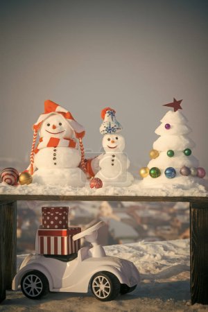 Snow sculptures on wooden table on grey sky