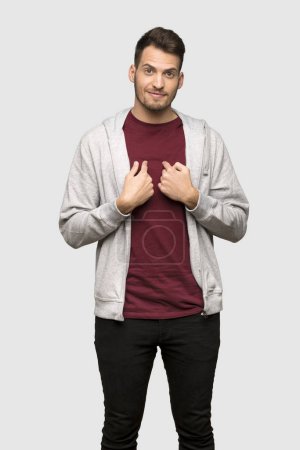 Man with sweatshirt with surprise facial expression over grey background