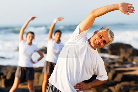 mid age man exercising at the beach