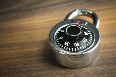 Combination lock on the wooden background