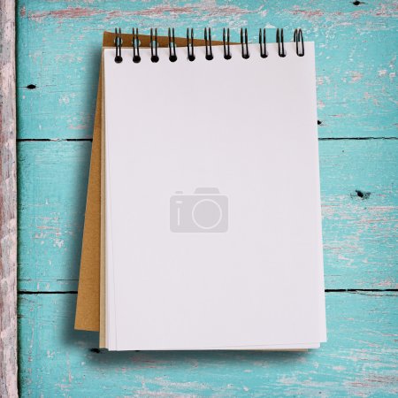 Open blank notebook on grunge wood background in green color.