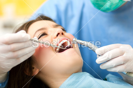 Dentist curing a female patient