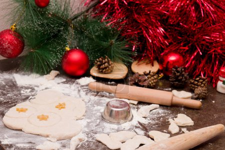 making christmas cookies, wooden kitchen utensils, red christmas decorations, batter for baking, cookie mold