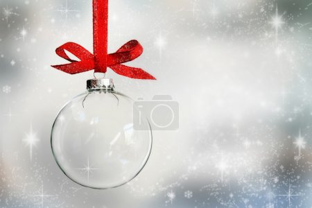 Transparent Christmas ball ornament on snowy background