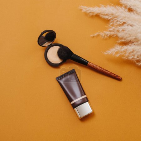 Composition of tools for everyday makeup over orange background. Top view