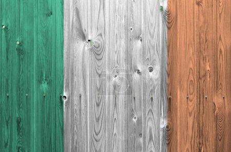 Ireland flag depicted in bright paint colors on old wooden wall close up. Textured banner on rough background