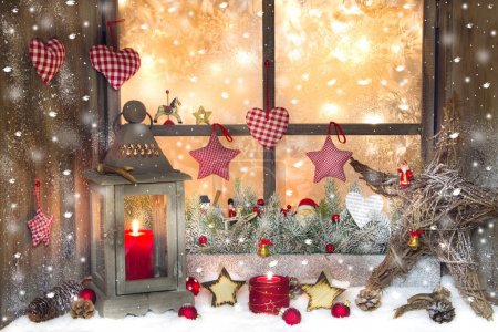 Red Christmas decoration with lantern on window sill with wood