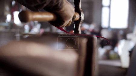 Blacksmith torque hot longer piece of metal in a spiral using a hammer