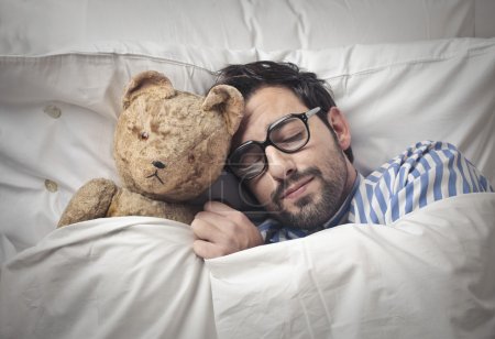 Man holding his teddy into bed