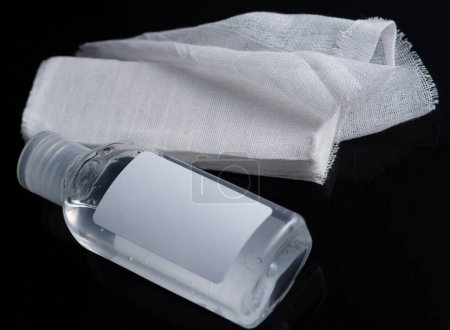 White medical cotton gauze bandage and antiseptic gel on white, black background, Medical bandage of new first aid gauze unrolling