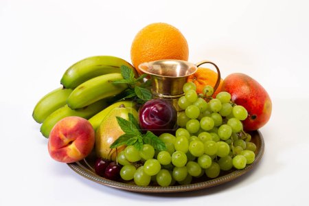 Assortment of exotic fruits on a tray with a jug on a white background. Healthy lifestyle concept.