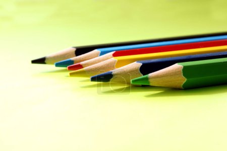 Colored pencils on a yellow background. Lots of different colored pencils. Colored pencil. Pencils are very sharp. Pencils are on the right. Side view. Close-up. Copy space. Background. Flat lay.