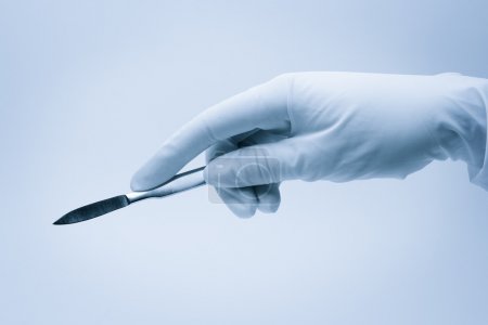 Hand of surgeon with scalpel during surgery