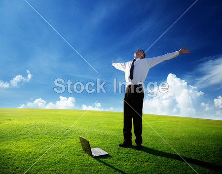 Happy young businessman on spring field
