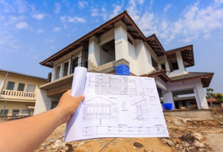 architecture drawings in hand on big house building 