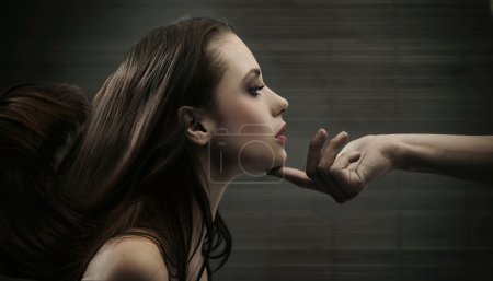 Conceptual image of a hand holding a woman's head