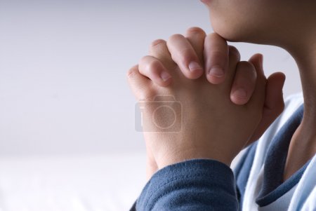 Small boy praying before going to bed