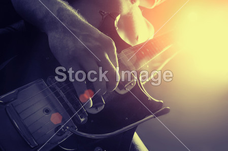 Man playing electrical guitar in black and yellow