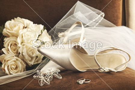 Wedding shoes with bouquet of white roses and ring